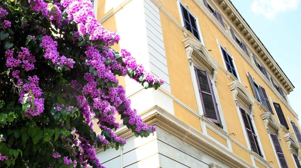 a building with purple flowers in front of it at Roma Room Hotel in Rome