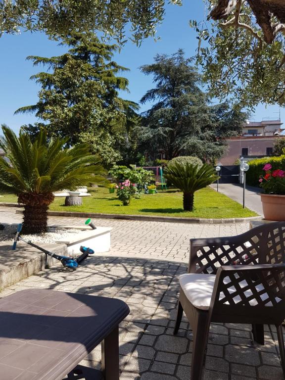 un patio con 2 bancos y un scooter en un parque en Il Giardino Di Stella en Frascati
