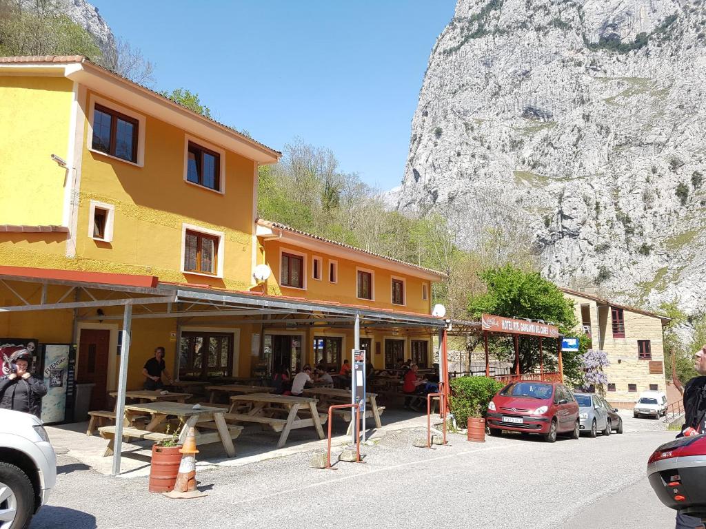 eine Straße mit einem Gebäude und einem Berg im Hintergrund in der Unterkunft Hotel Garganta del Cares in Poncebos