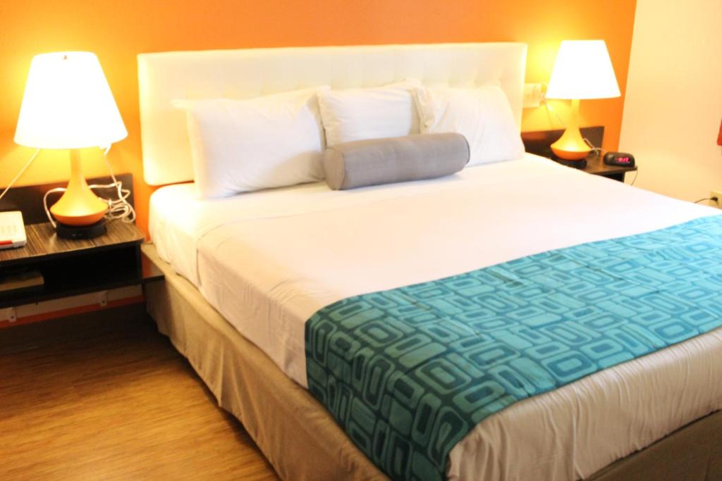 a large bed in a hotel room with two lamps at Howard Johnson by Wyndham Lake George in Lake George