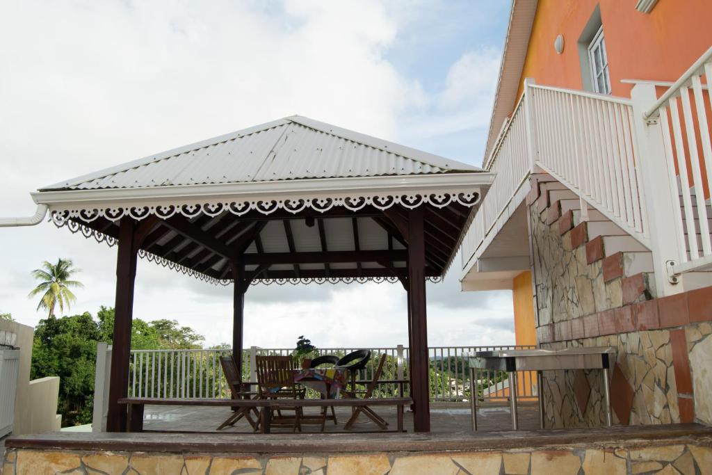 a wooden gazebo with a table and chairs on a patio at Domaine De Titine in Bonneville