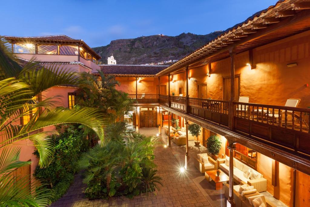 une cour intérieure d'un bâtiment avec des canapés et des plantes dans l'établissement Hotel LIVVO La Quinta Roja, à Garachico