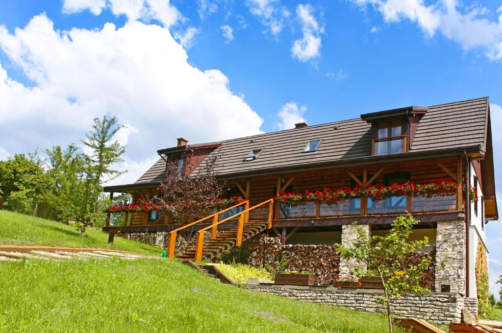 a house on a hill with flowers on it at Podlesice 38 in Kroczyce