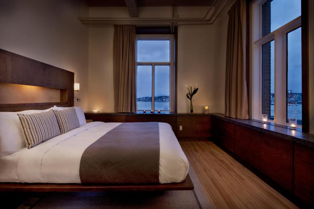 - une chambre avec un grand lit et de grandes fenêtres dans l'établissement Hotel 71 by Preferred Hotels & Resorts, à Québec