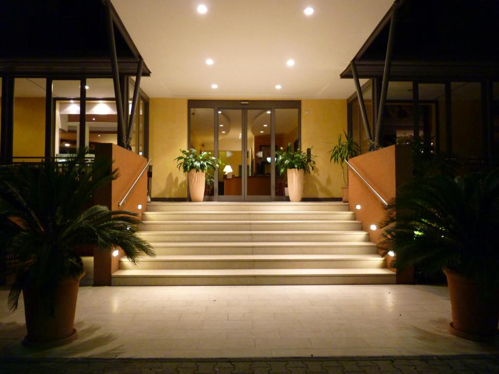una hall con scale e piante in vaso in un edificio di Hotel Gambrinus a Lido di Jesolo