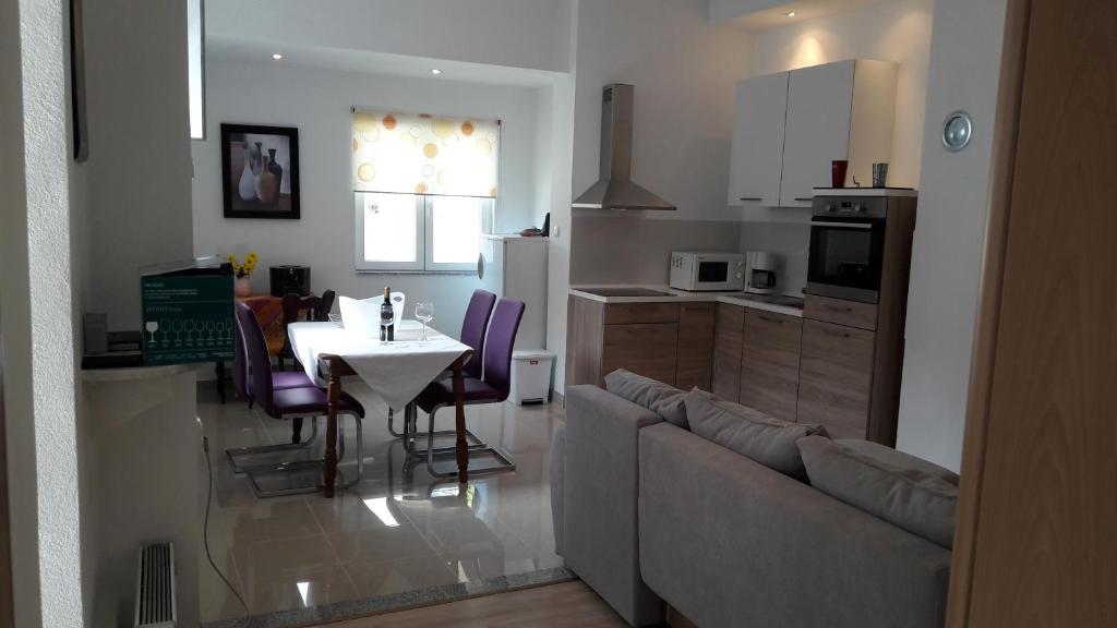 kuchnia i salon ze stołem i kanapą w obiekcie Apartment Sara w mieście Zadar