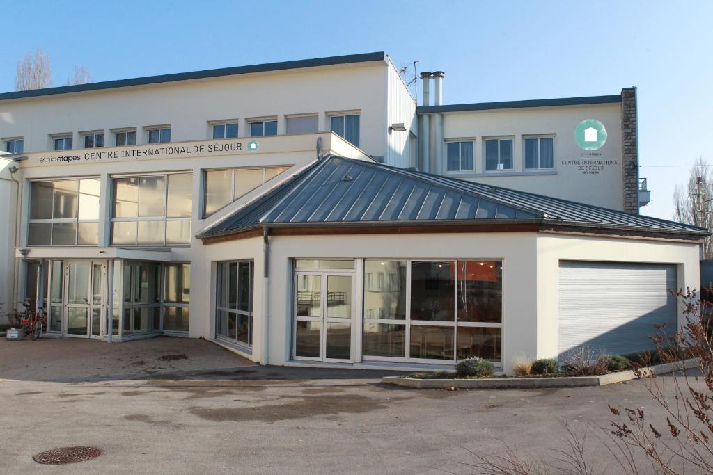 a large white building with a garage at Ethic Etapes CIS de Besançon in Besançon