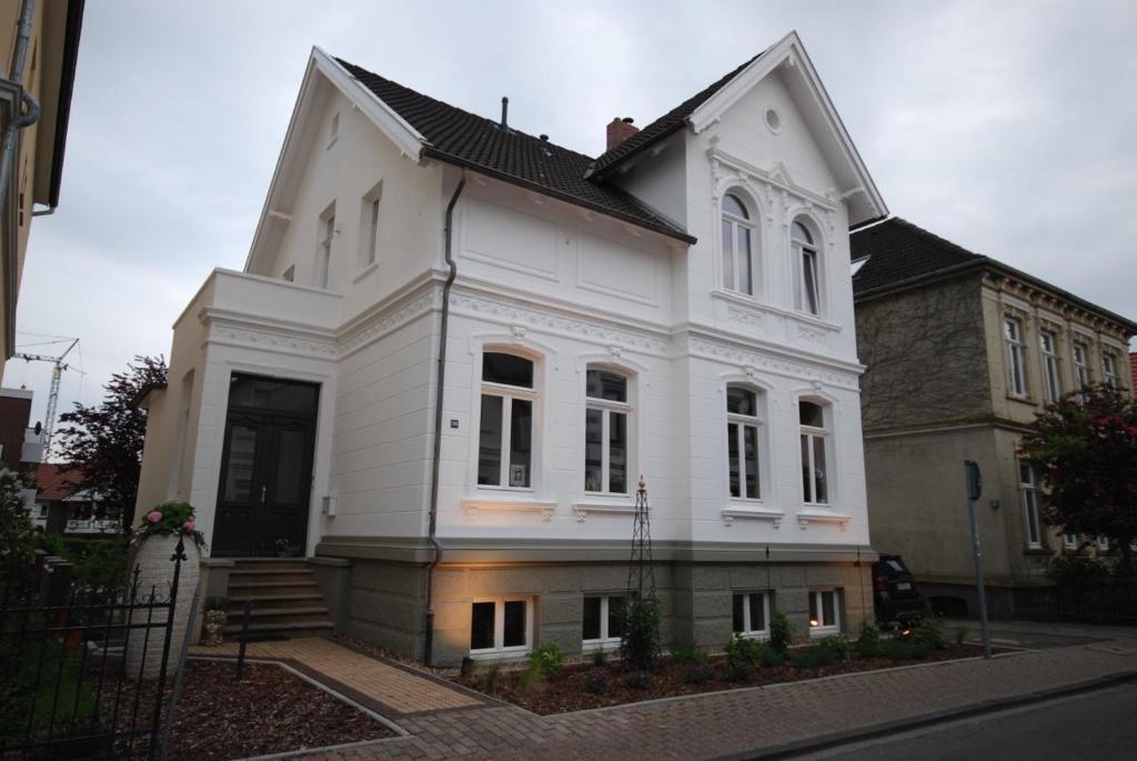 een wit huis met een zwart dak bij Stadthaus Oldenburg in Oldenburg