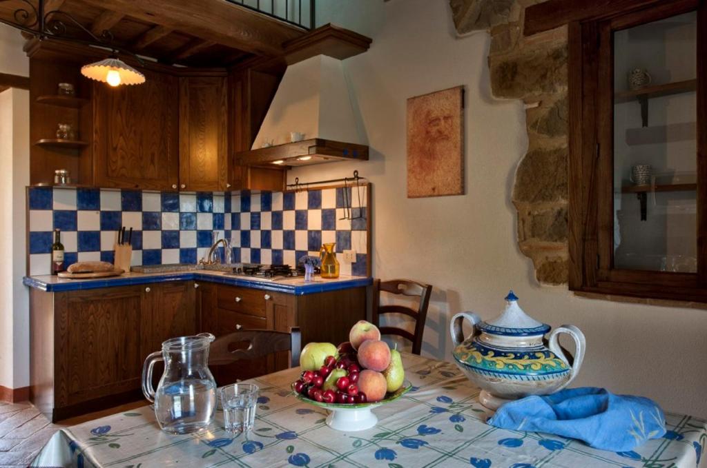 a kitchen with a table with a bowl of fruit on it at La Dragona in Castel del Piano