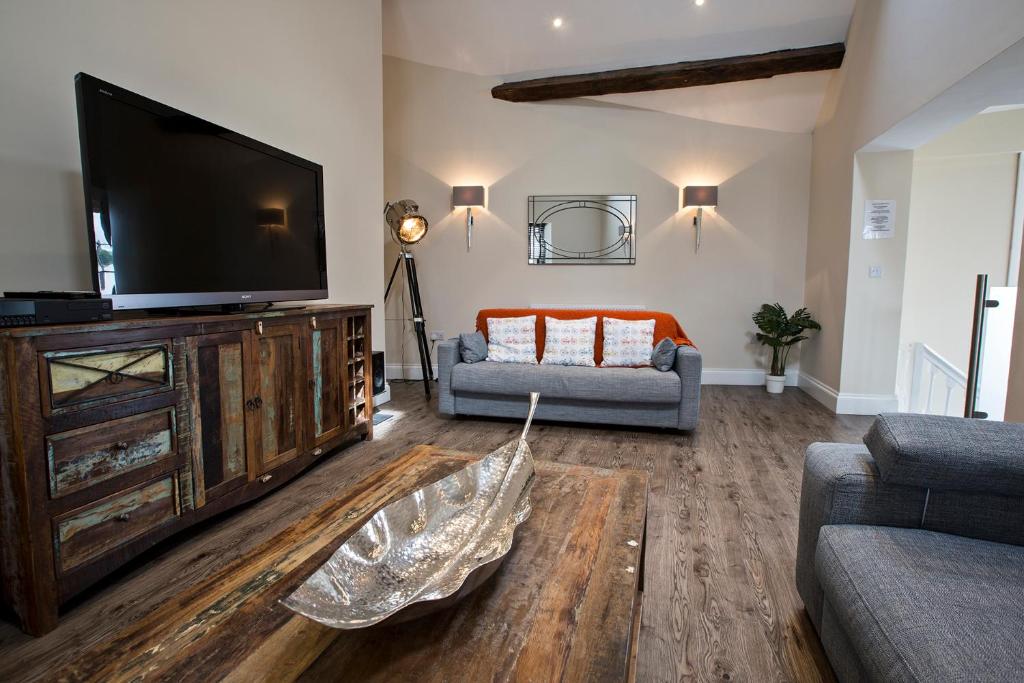 a living room with a flat screen tv and a couch at Cider House in Ulverston