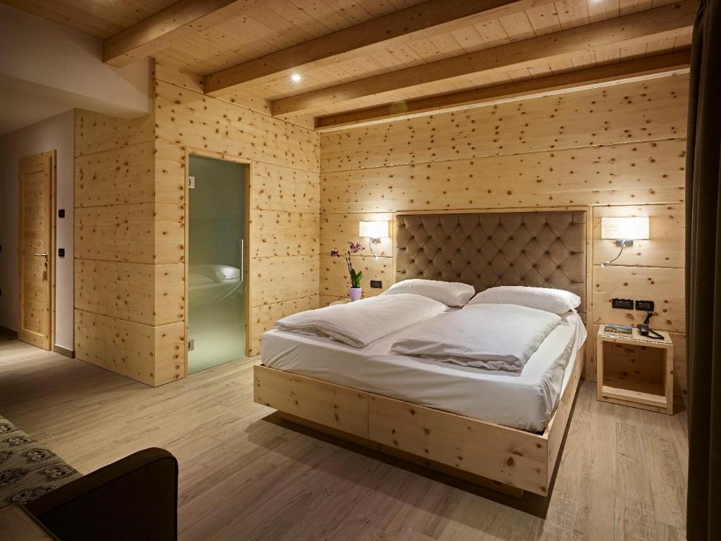 レードロにあるHotel Garni Minigolfのベッドルーム(大型ベッド1台、バスタブ付)