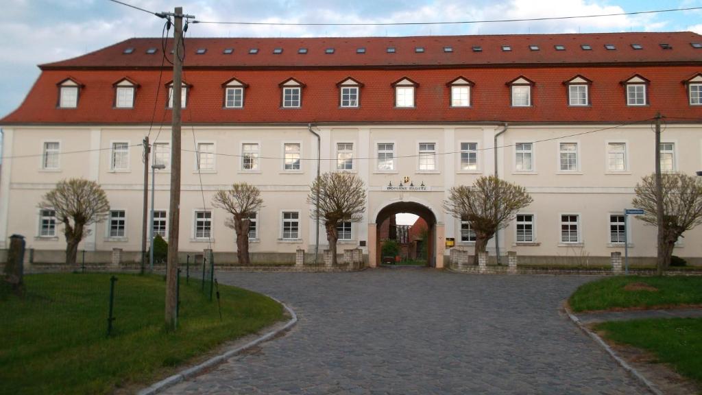 a large white building with a red roof at Domäne-Badetz in Badetz