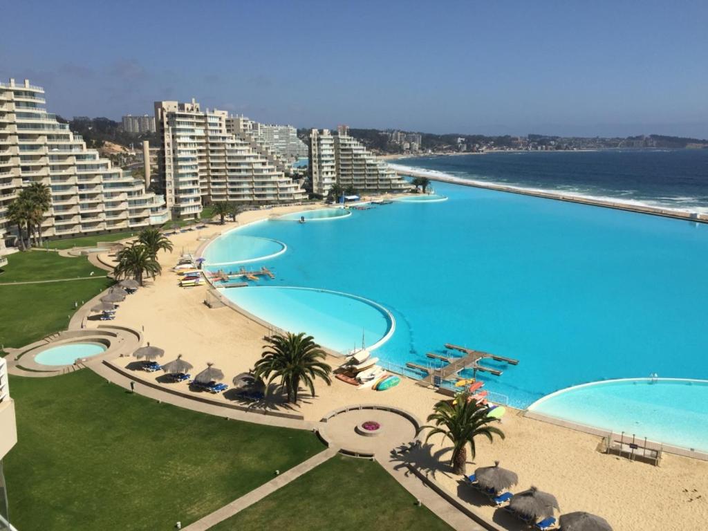 uma vista superior de uma grande piscina ao lado do oceano em Apartamento en San Alfonso del Mar 3D-2B em Algarrobo