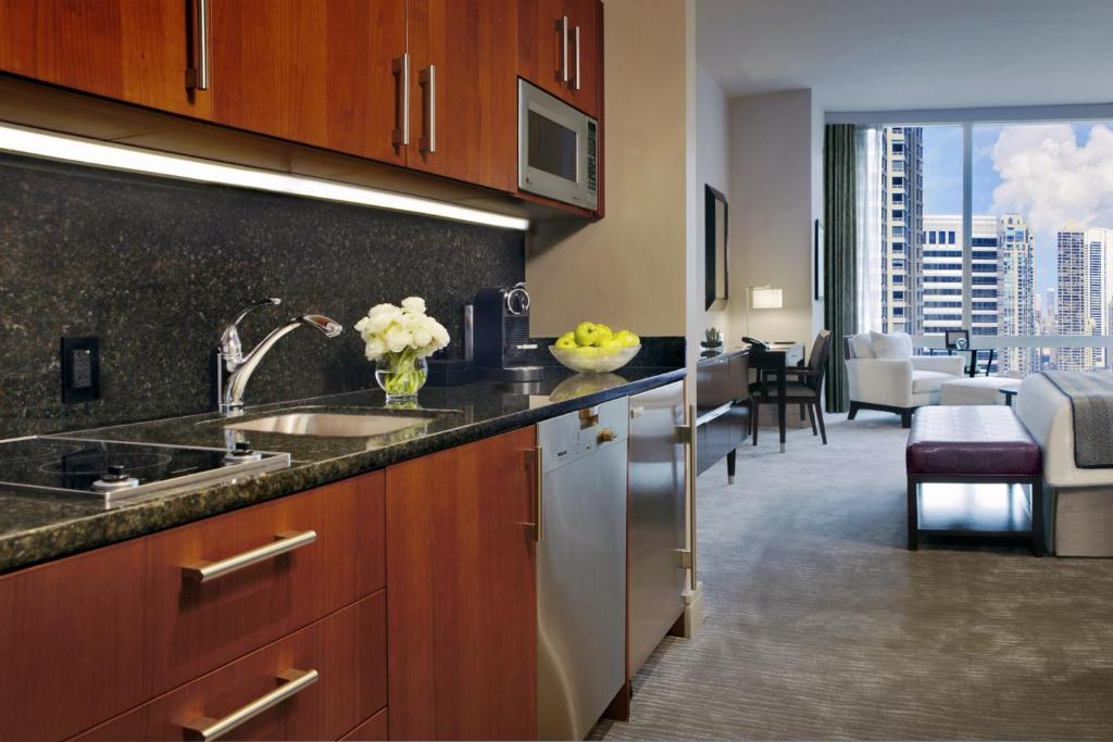 a kitchen with a sink and a living room at Trump International Hotel & Tower Chicago in Chicago