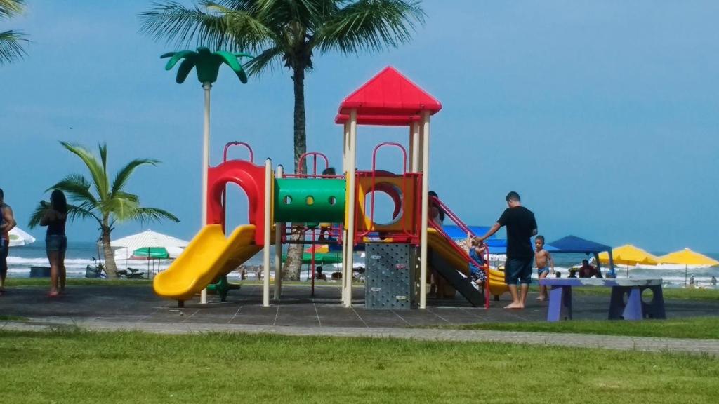 um parque infantil na praia com pessoas a brincar em Pousada Enseada de Bertioga em Bertioga