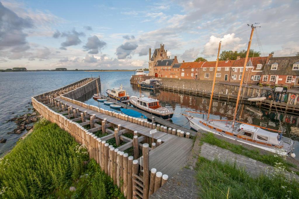 un groupe de bateaux amarrés à un quai sur l'eau dans l'établissement Auberge de Campveerse Toren, à Veere