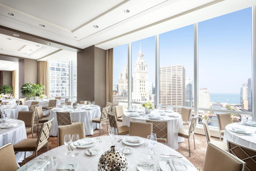 a restaurant with white tables and chairs and large windows at Trump International Hotel & Tower Chicago in Chicago