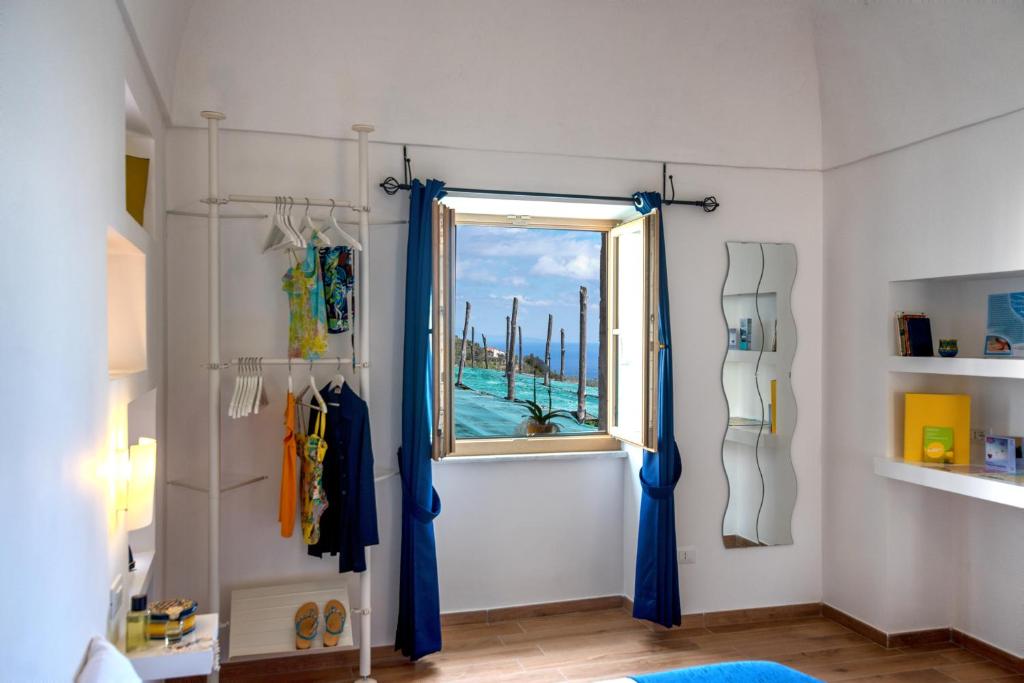 マッサ・ルブレンセにあるMaison Margheritaの窓と青いカーテンが備わるお部屋