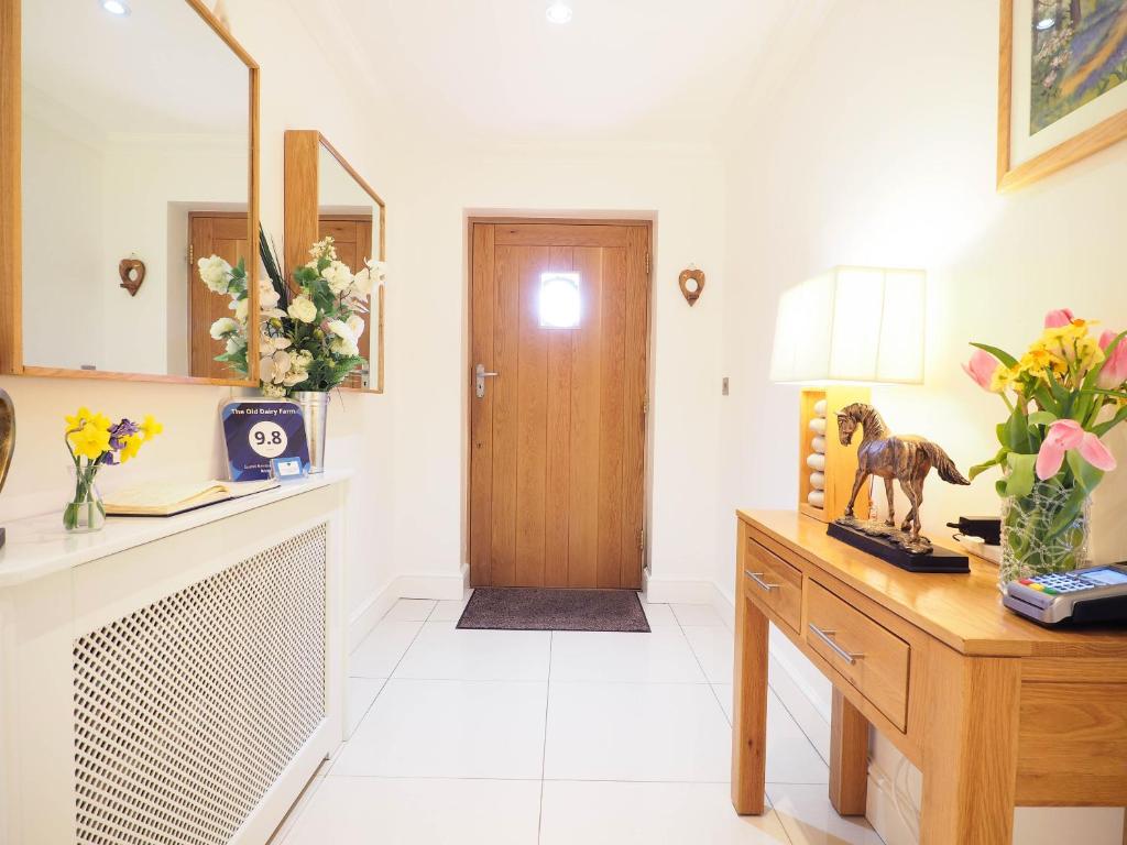 a hallway with a door and a table with flowers at The Old Dairy Farm in Emsworth