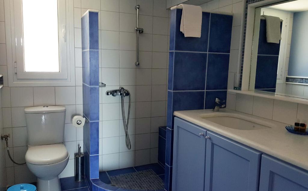 a bathroom with a toilet and a sink and a shower at PLEIADES lUXURY APARTMENTS in Porto Heli