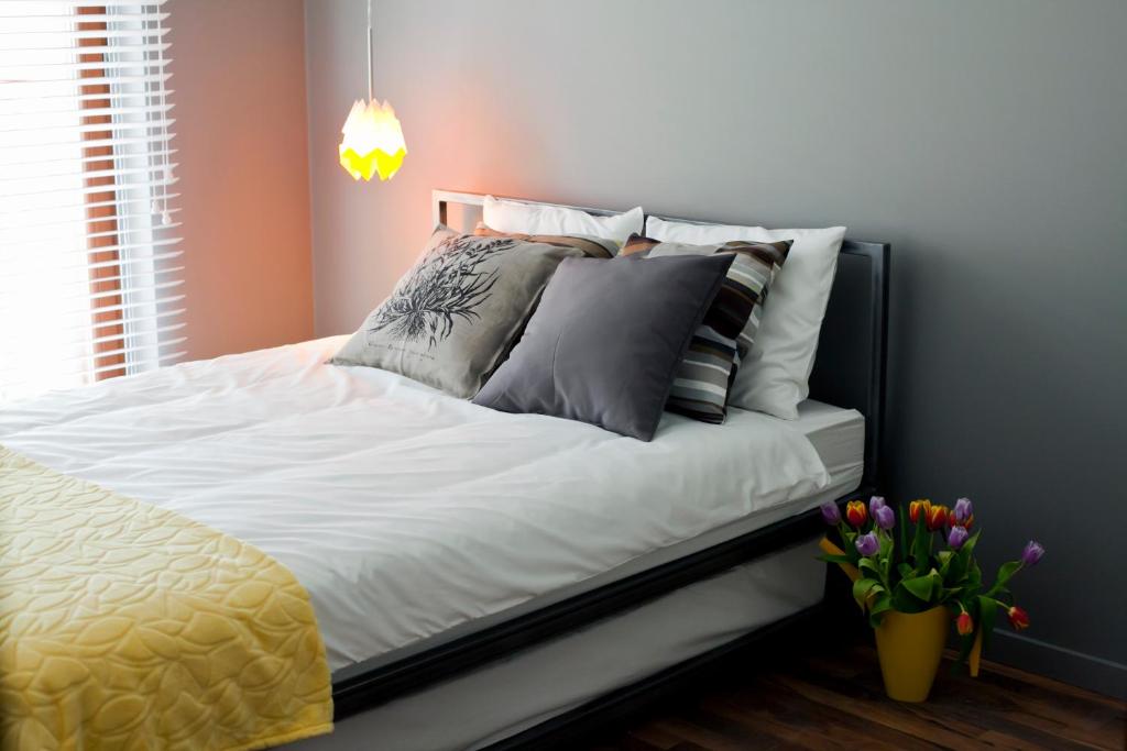 a bed with white sheets and pillows in a bedroom at Apartament Wśród Drzew in Gdańsk