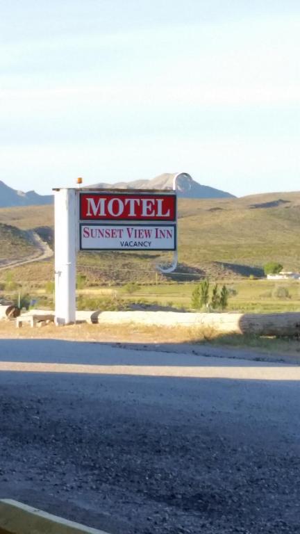 ein Schild für ein Motel am Straßenrand in der Unterkunft Sunset View Inn L.L.C in Alamo