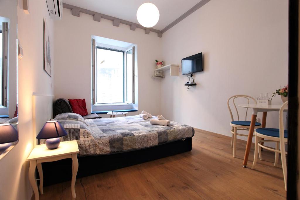 a bedroom with a bed and a table and a tv at The heart of Dubrovnik in Dubrovnik