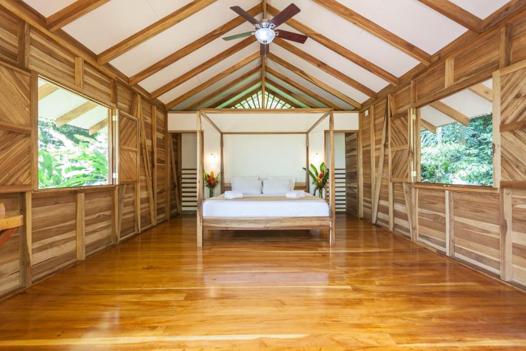 een slaapkamer met een bed in een kamer met houten wanden bij Relax Natural Village Adults Only in Puerto Viejo