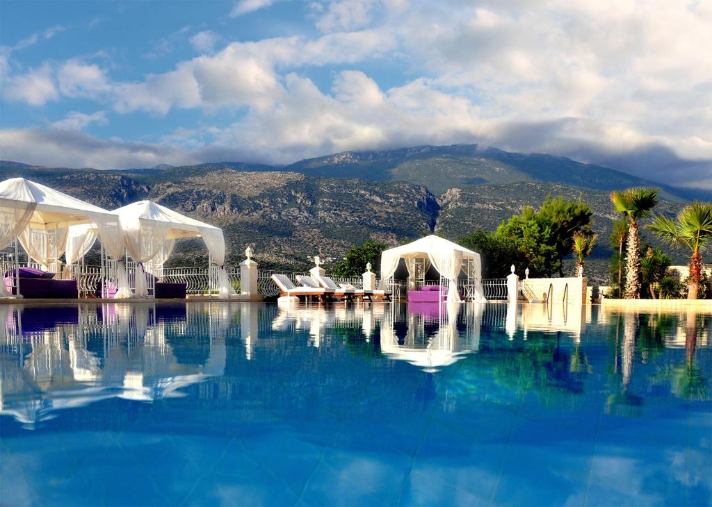 una piscina de agua con tiendas de campaña y una montaña en el fondo en Lukka Exclusive Hotel – Adult Only +12 en Kas