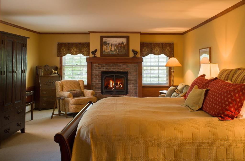 a bedroom with a large bed and a fireplace at Reluctant Panther Inn & Restaurant in Manchester