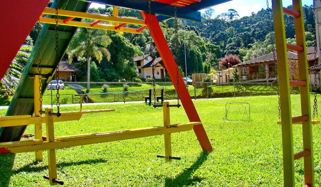 um parque infantil com um baloiço num parque em Pousada Rosa em Gramado