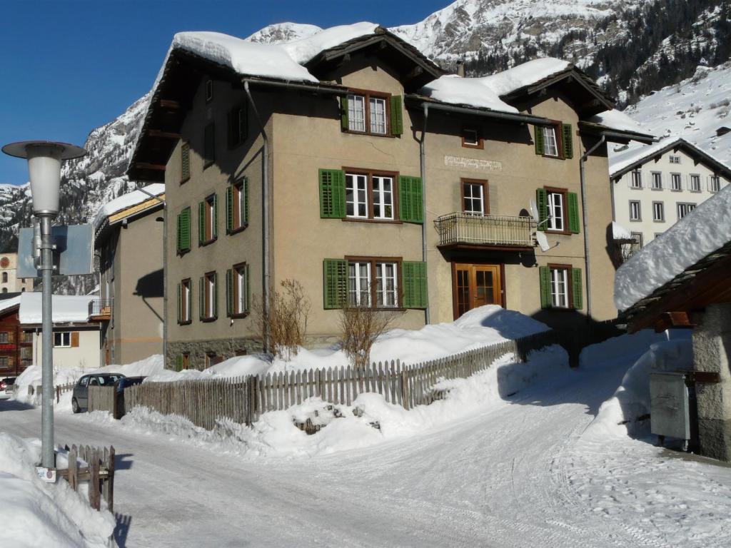 ein Haus im Schnee mit einem Zaun in der Unterkunft Apartment Verena in Vals