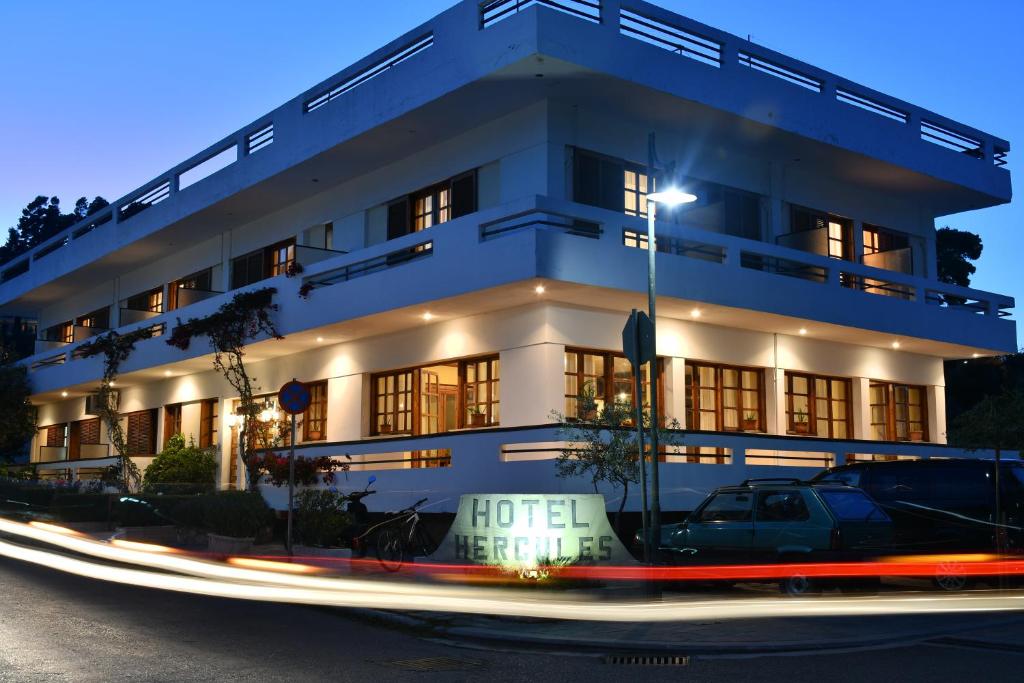 Hotel Hercules في أوليمبيا: مبنى ابيض وامامه لافته للفندق