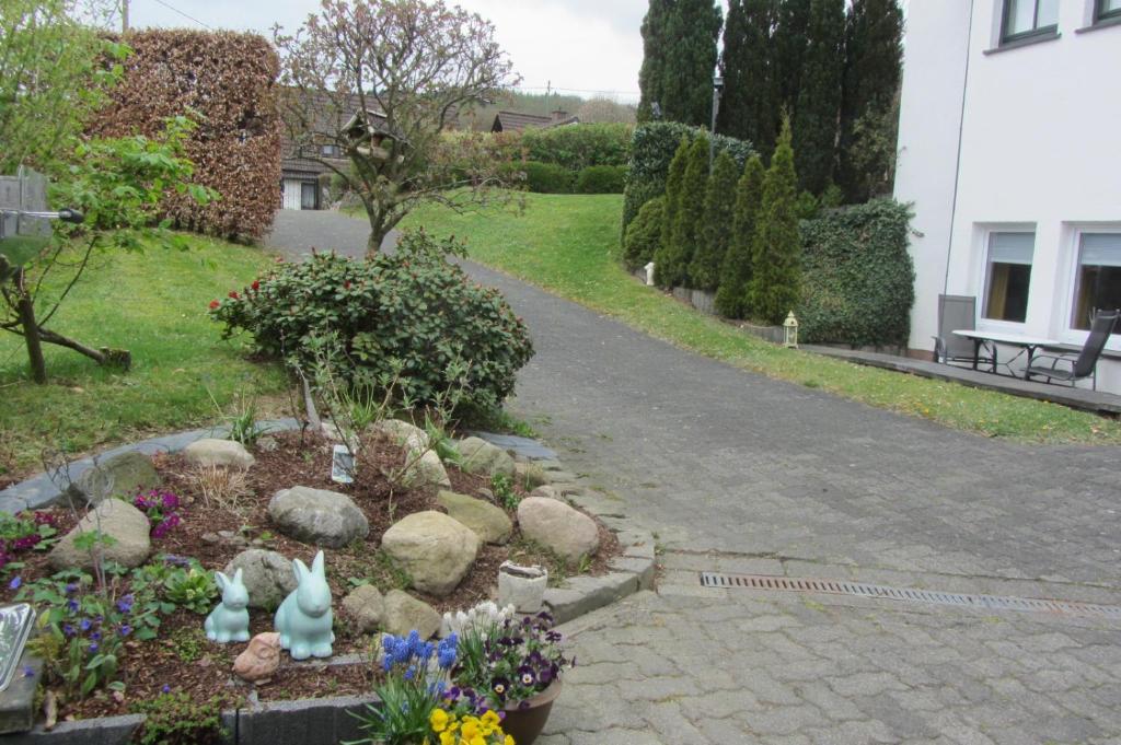 un jardín con conejos y flores en un camino de entrada en Boardinghouse Haltestelle en Krombach