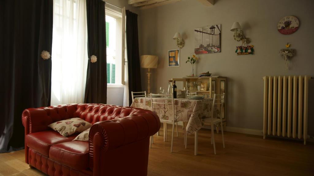 フィレンツェにあるMargherita Suiteのリビングルーム(赤いソファ、テーブル付)