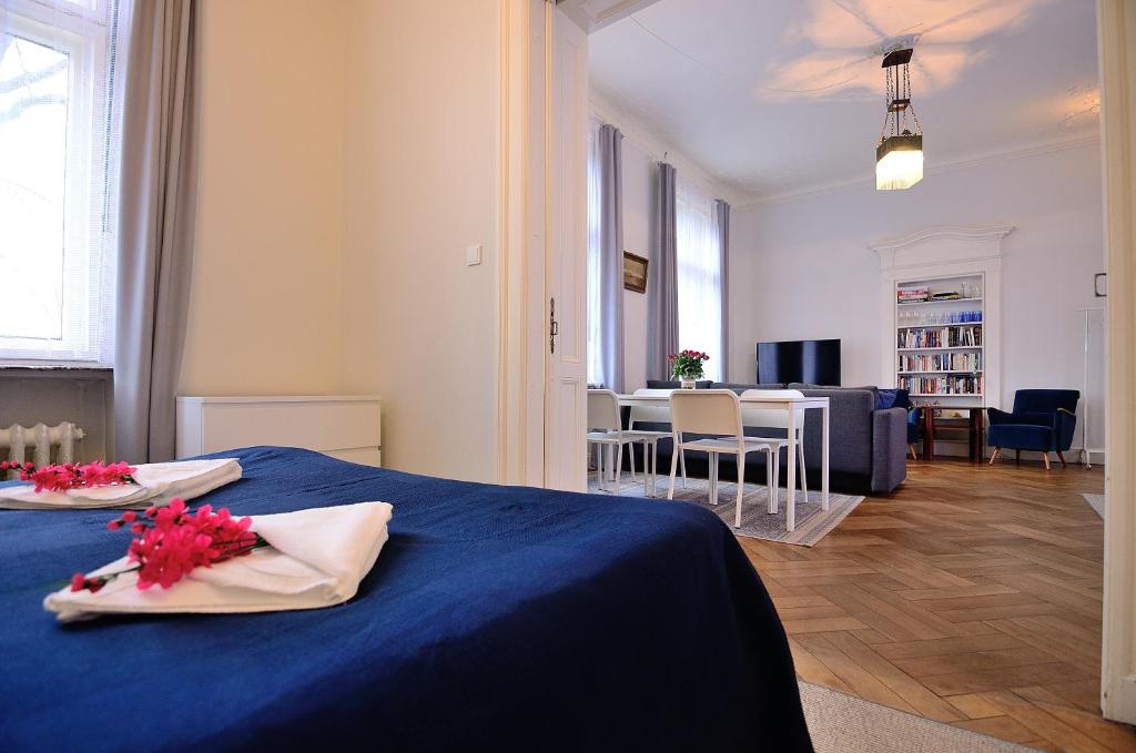 um quarto com uma cama azul e uma sala de estar em Victus Apartamenty Apartament Bolek i Lolek em Sopot