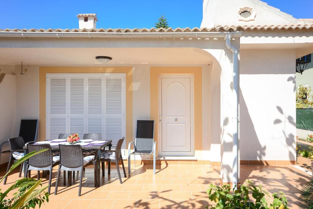 a patio with a table and chairs in front of a house at Pinya in Port d'Alcudia