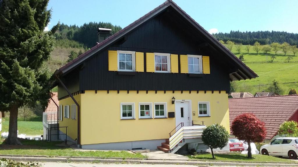 una casa gialla e nera con tetto nero di Ferienwohnung am Siegelbächle mit E-Bikes Vermietung a Gutach im Breisgau
