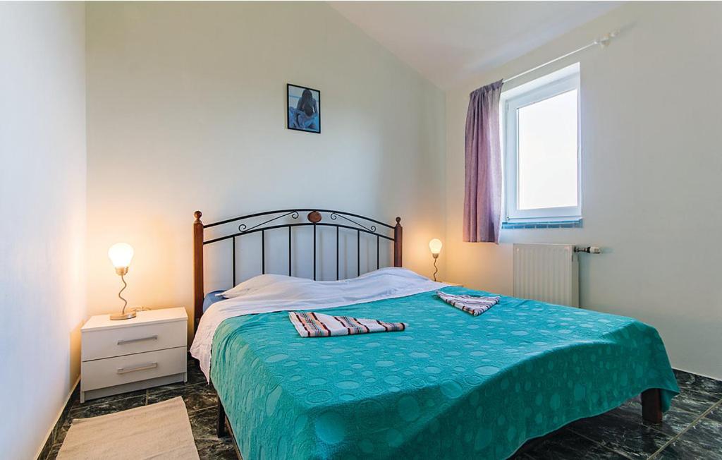 sypialnia z łóżkiem z niebieskim kocem i oknem w obiekcie Apartments Ivo 1328 w Fažanie