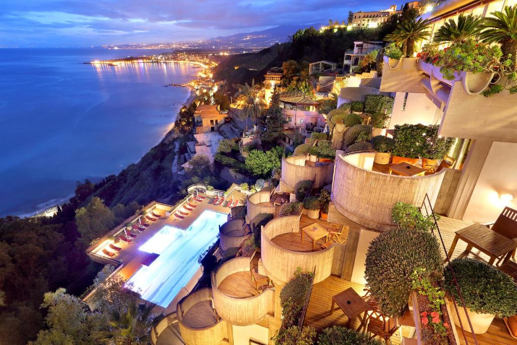 an aerial view of a resort with a pool and the ocean at Eurostars Monte Tauro in Taormina