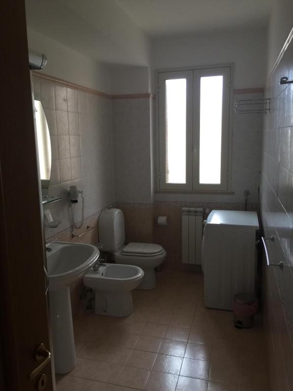 a bathroom with a toilet and a sink and a tub at Casa Vacanze Samira in Fondachello