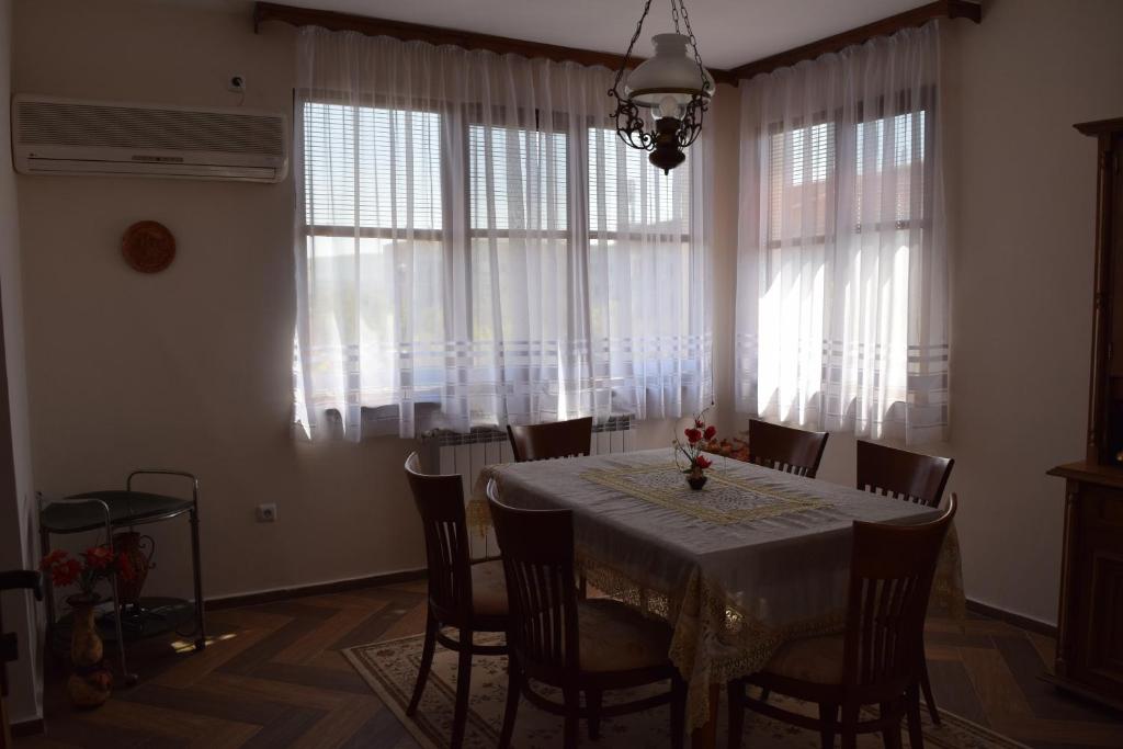 a dining room with a table and some windows at Grande Apartment in Tsarevo
