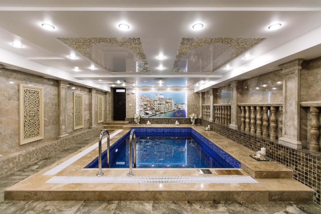 a swimming pool in a room with a ceiling at Bellagio Hotel in Rostov on Don