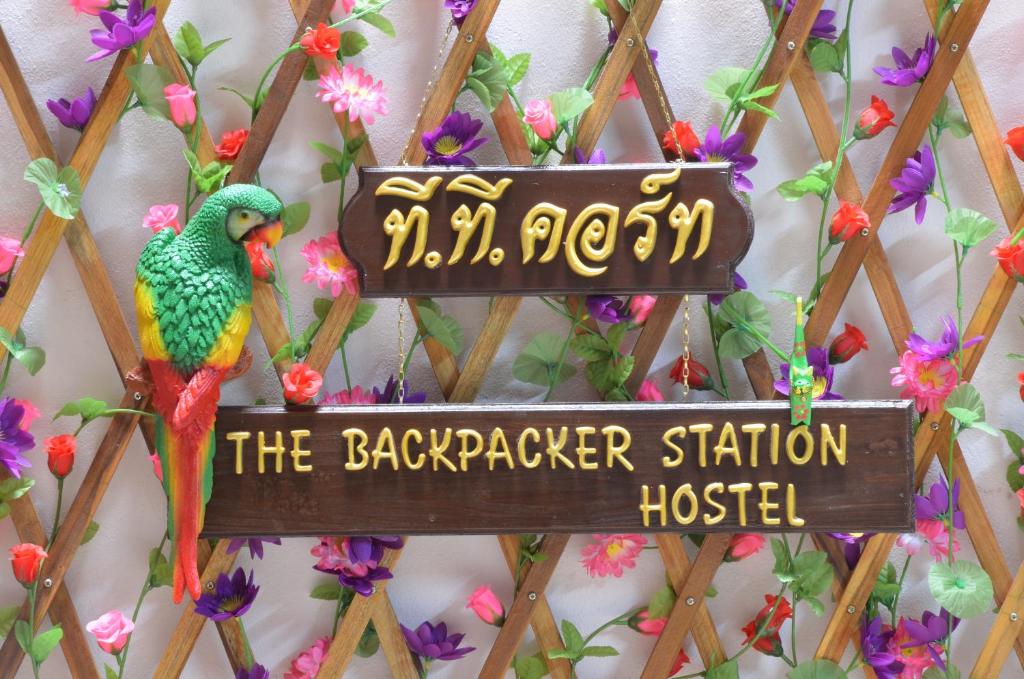 a sign with a parrot on a wall at The Backpacker stn in Nonthaburi