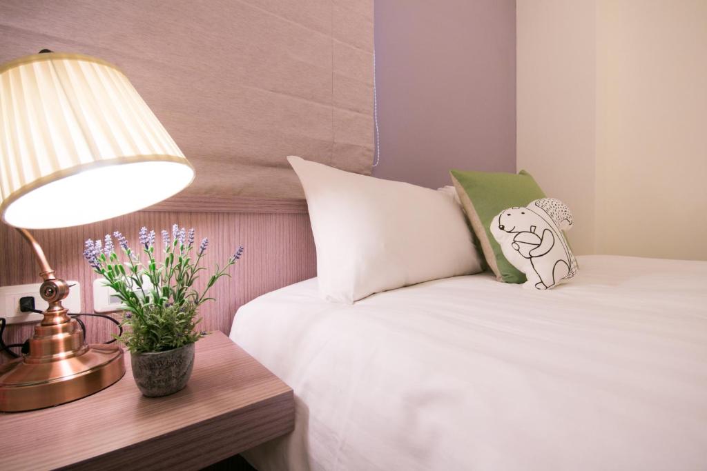 吉安的住宿－花蓮天外天民宿，一间卧室配有床、灯和鲜花
