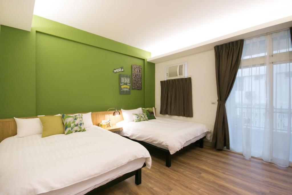 a room with two beds and a green wall at Skyview B&amp;B in Ji&#39;an