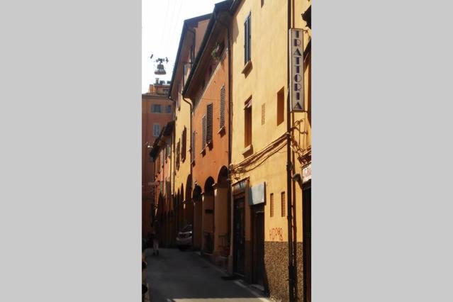 ボローニャにあるa quattro passiの通り沿いの建物のある路地の眺め