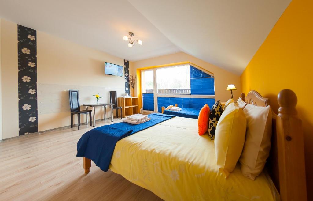 a bedroom with a large bed with blue and yellow walls at Willa Zacisze in Ustroń