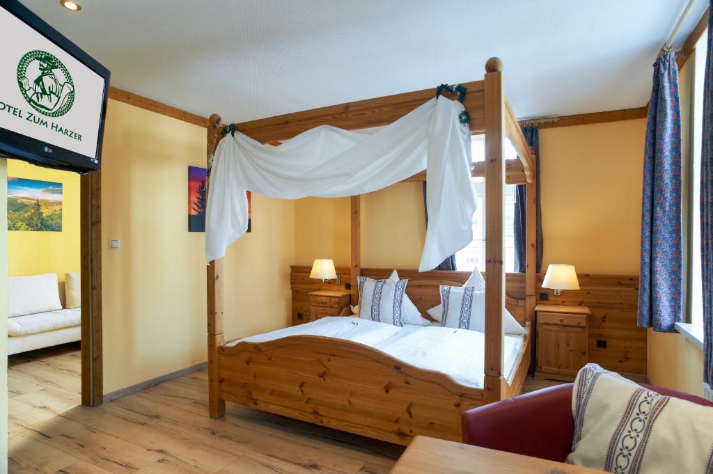 Schlafzimmer mit einem Holzbett mit Baldachin in der Unterkunft Hotel Zum Harzer in Clausthal-Zellerfeld