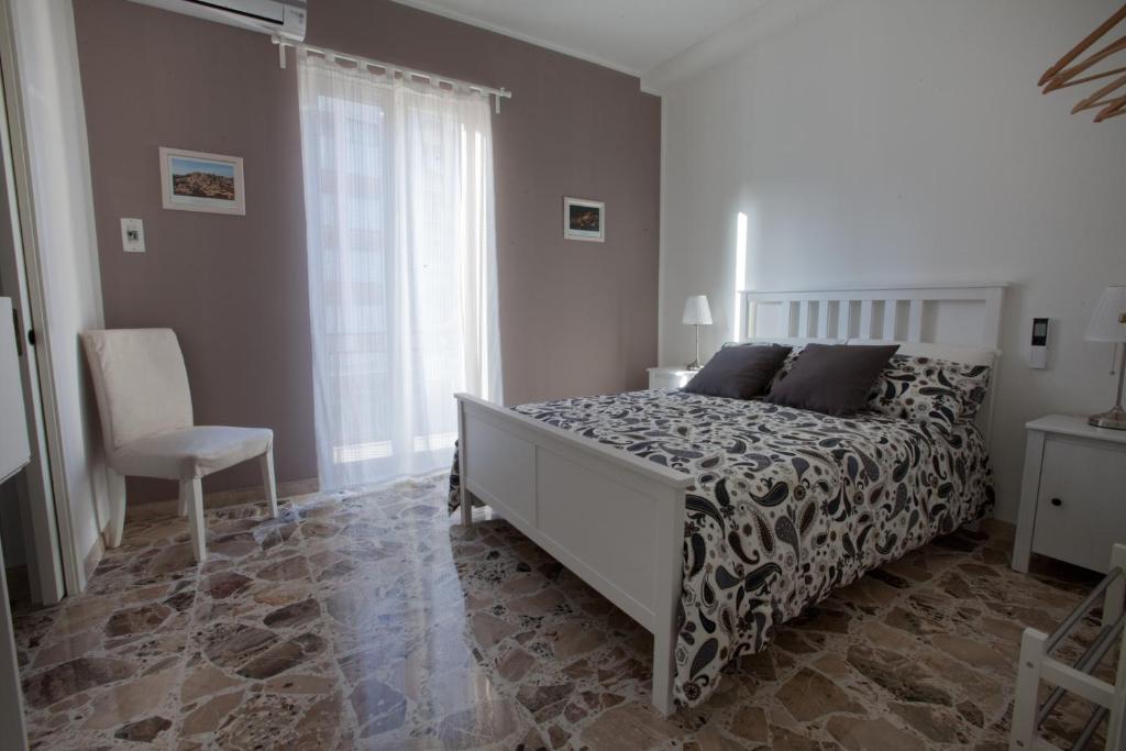 a bedroom with a bed and a chair and a window at Casa Madonna delle Grazie in Modica